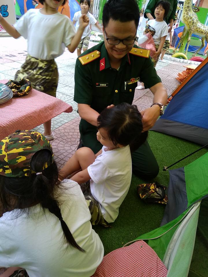 Chú bộ đội buộc tóc cho “chiến sĩ nhí”.