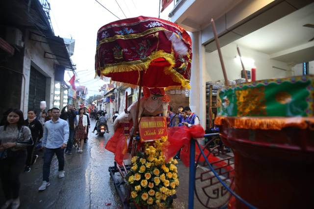 Đúng 18h ngày 13 tháng Giêng, những chiếc đèn lồng, đèn nháy trang trí khắp đường làng, ngõ xóm đồng loạt sáng cũng là lúc các “ông lợn” và lễ vật được người dân rước qua các ngõ, đường làng với tiếng trống rộn ràng, linh đình