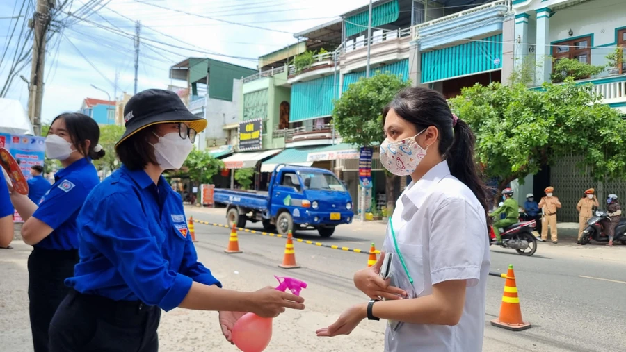 Thí sinh sát khuẩn trước khi vào phòng thi tại điểm thi trường THPT chuyên Lê Khiết.