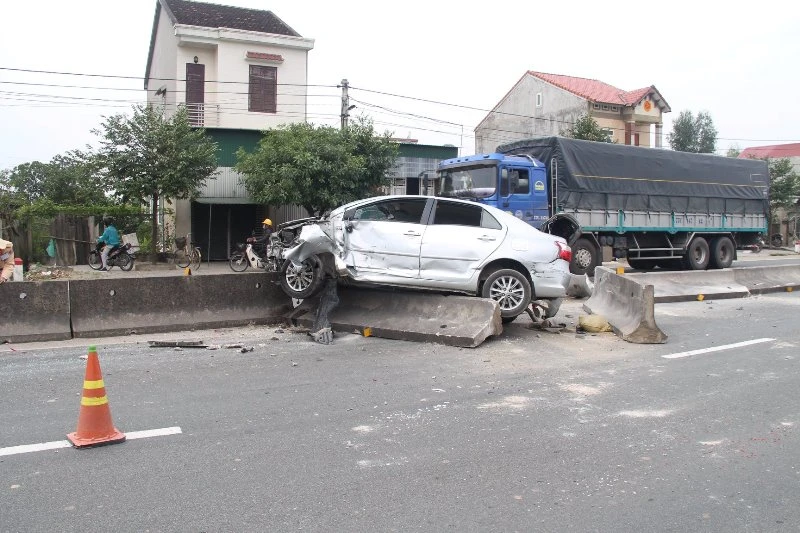 Xe ô tô con leo lên dải phân cách, bị hư hỏng nặng.