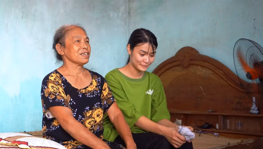 Em Đoàn Thị Nhung bên cạnh bà nội của mình.