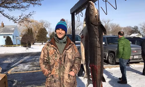 Jon Eiden và con cá tầm dài hơn hai mét. Ảnh: KFOX.
