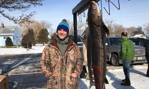 Jon Eiden và con cá tầm dài hơn hai mét. Ảnh: KFOX.
