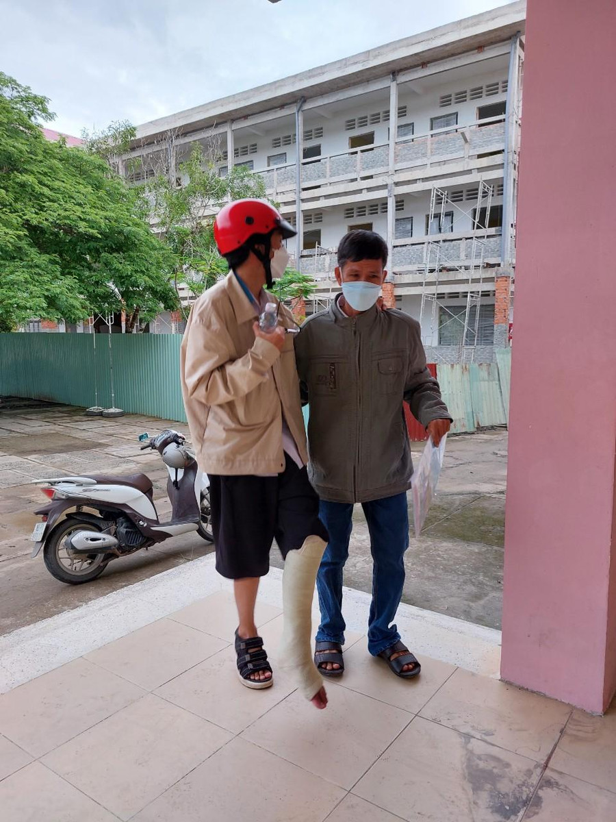 Thí sinh Phú bị thương chân được người nhà đưa đến phòng thi.