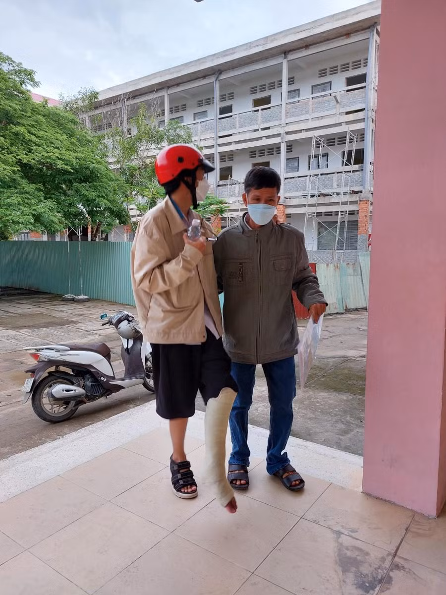Thí sinh Phú bị thương chân được người nhà đưa đến phòng thi.