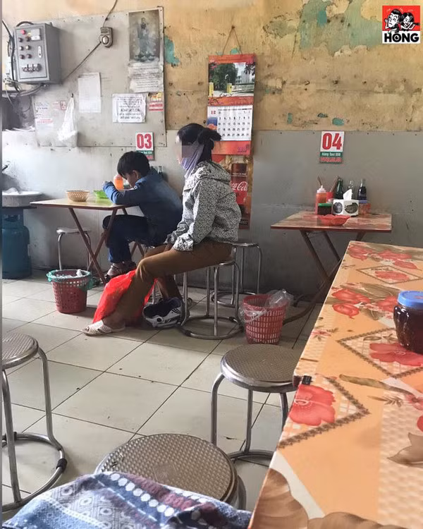 Người mẹ ngồi phía sau lẳng lặng ngắm cậu con trai thưởng thức tô phở ngon lành khiến nhiều người xúc động. Ảnh: Xuân Hùng.