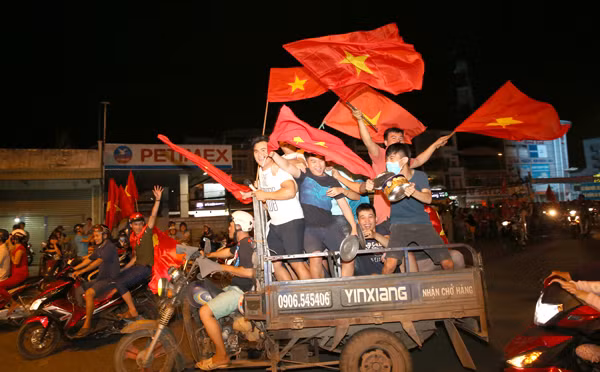 Xe ba gác chở kín người ăn mừng chiến thắng của tuyển Việt Nam trong trận bán kết với Philippines. (Ảnh: TTXVN) 