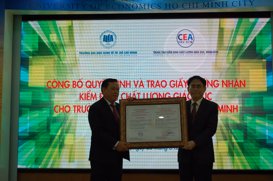 DHKT: PGS.TS Nguyễn Hội Nghĩa Phó Giám đốc ĐHQG TP.HCM trao Chứng nhận kiểm định chất lượng giáo dục cho GS.TS Nguyễn Đông Phong – hiệu trưởng UEH