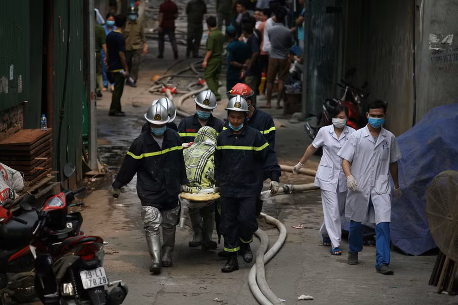 Lực lượng chức năng đưa thi thể nạn nhân ra khỏi hiện trường vụ cháy.