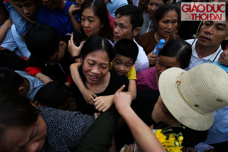 Trẻ nhỏ được người lớn cõng trên lưng do quá đông người.