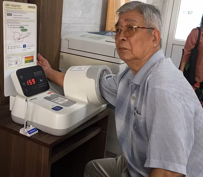 Người lớn tuổi được đo huyết áp trước khi khám bệnh. Ảnh: Cẩm Anh