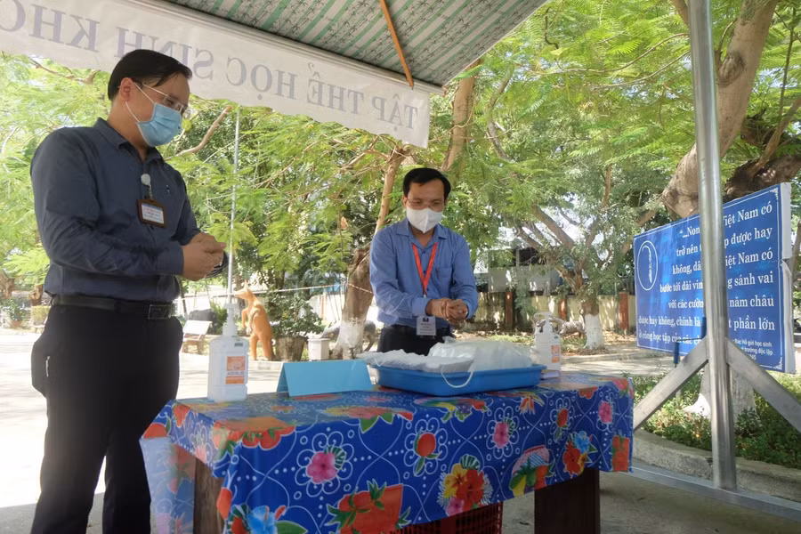 Ông Mai Văn Trinh (bên phải) rửa tay sát khuẩn trước khi vào kiểm tra.