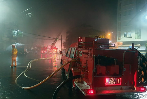 Cảnh sát dùng xe thang chữa cháy trong mưa. Ảnh:Hoàng Hạnh. Cảnh sát dùng xe thang chữa cháy trong mưa. Ảnh: Hoàng Hạnh.