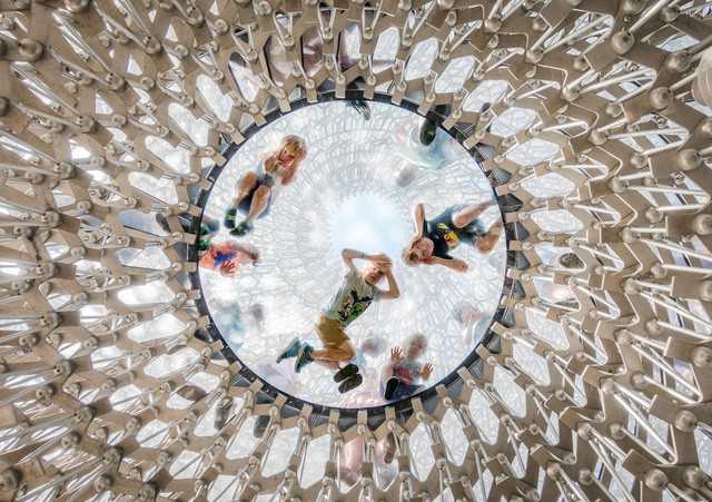 Trẻ nhỏ nằm trên sàn kính để quan sát những du khách ở bên dưới. Ảnh chụp tại một công trình nằm bên trong Vườn thực vật hoàng gia Kew, London, Anh. Ảnh: Omer Kanipak