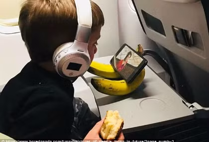 Chú bé tận dụng quả chuối làm giá đỡ điện thoại để dễ xem. Chú bé tận dụng quả chuối làm giá đỡ điện thoại để dễ xem.