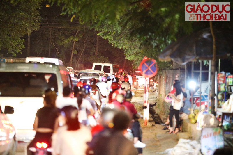 Phía bên ngoài hàng dài xe nối đuôi nhau nhích dần vào bên trong lễ hội