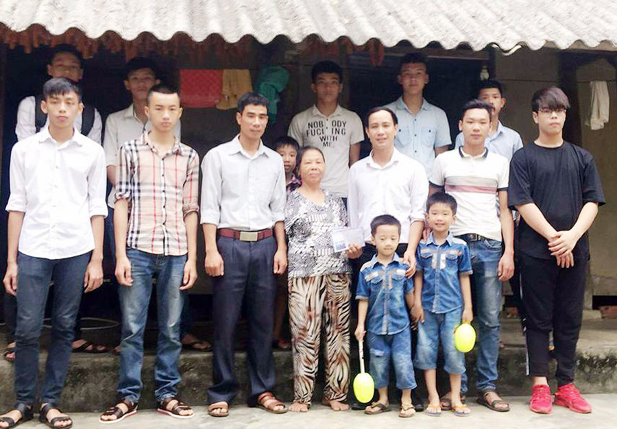 Thầy giáo Nguyễn Quang Đại (thứ 3 từ phải sang) trao quà cho người nghèo khi tổ chức thiện nguyện