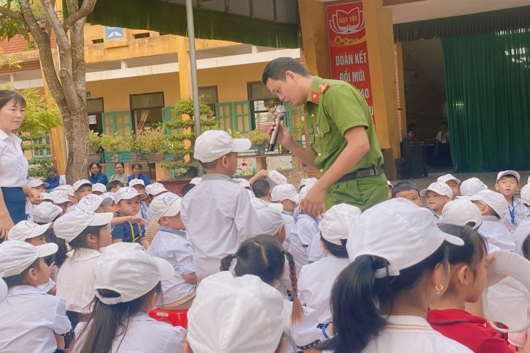 Các em học sinh đặt câu hỏi với cán bộ Công an xã về thuốc lá điện tử, cách phòng cháy chữa cháy.
