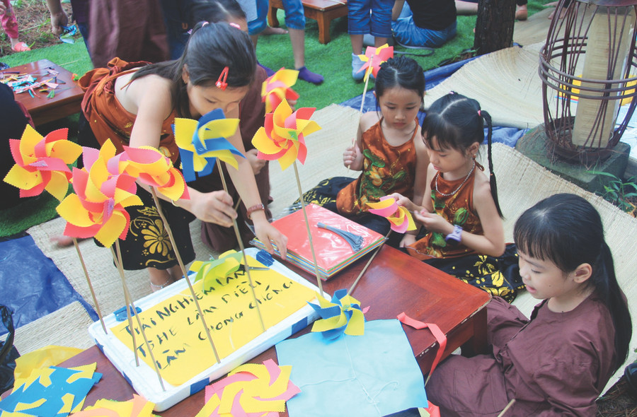 Các em nhỏ được trải nghiệm làm chong chóng...