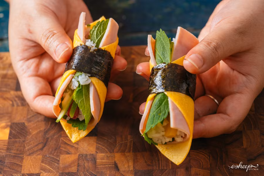 Cuối cùng là cuộn chặt tay như cuộn cơm bình thường rồi dán mép “dây nịt” rong biển lại là xong.