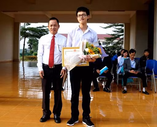 Thừa ủy quyền của UBND tỉnh Đắk Lắk, ông Đỗ Tường Hiệp trao Bằng khen và tiền thưởng cho em Đoàn Nam Thắng.