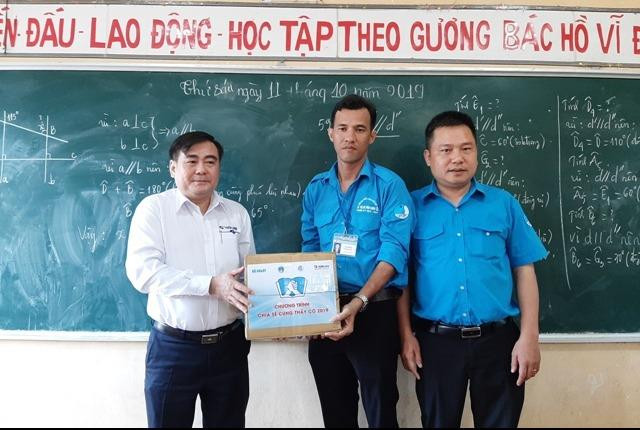 Thầy Thạch Minh Trí (giữa) nhận quà từ Công ty Thiên Long
