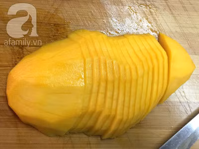 Xoài gọt vỏ, cắt 2 bên má xoài rồi cắt lát mỏng khoảng 2 mm.