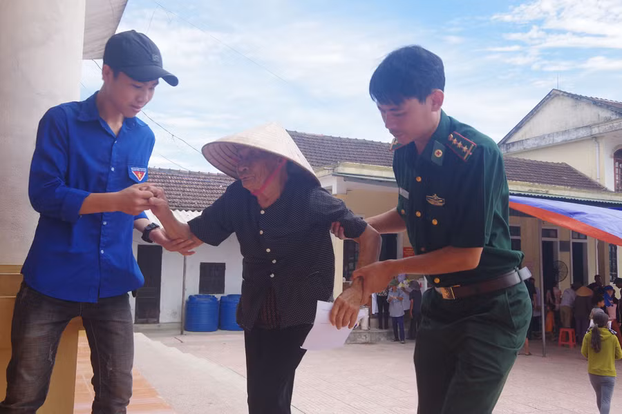 Chiến sĩ biên phòng và đoàn viên hỗ trợ người già đến khám bệnh