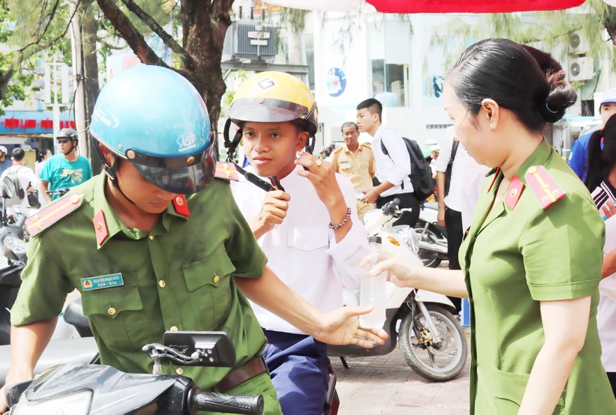 Các chiến sĩ công an Cà Mau đưa rước thi sinh tại điểm thi. Ảnh: T. Trang. 