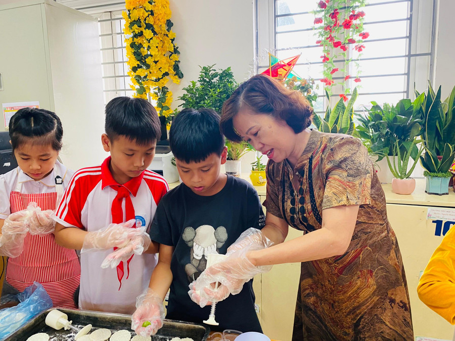 Cô Ngô Thị Thanh - Hiệu trưởng Trường Tiểu học Nam Từ Liêm trực tiếp hướng dẫn các em học sinh nặn bánh trung thu.
