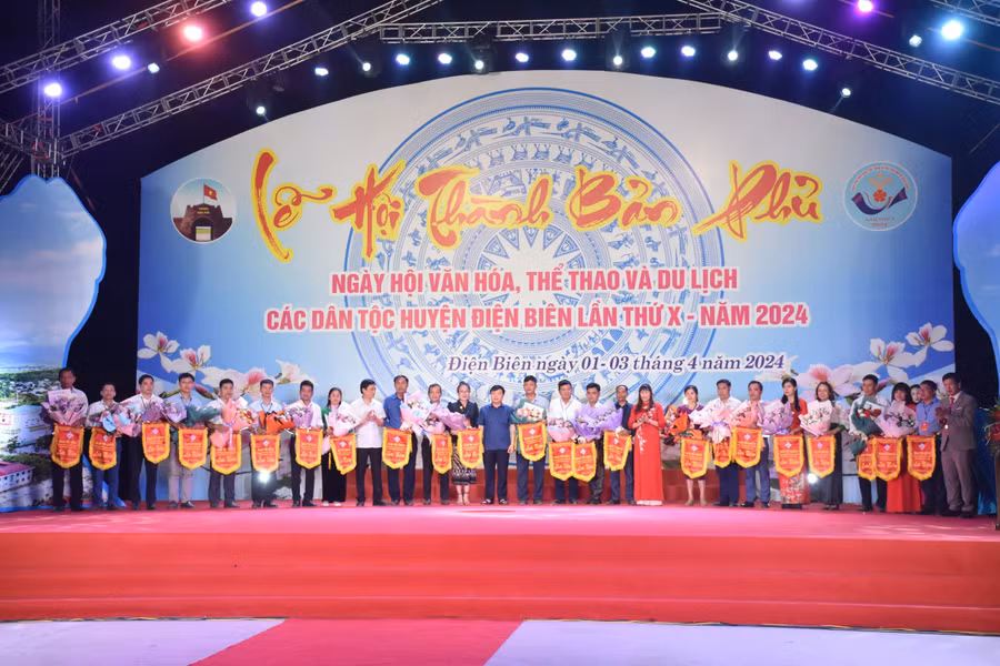 Đại diện các đoàn nghệ thuật quần chúng nhận hoa và cờ lưu niệm của Ban tổ chức.