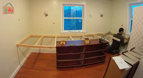 Người bố đơn thân này thường tự sửa chữa đồ dùng trong nhà nên anh tự mình thiết kế và thi công luôn. Để tăng diện tích sử dụng, anh nâng cao giường lên, mua một chiếc tủ để đồ đặt phía dưới.