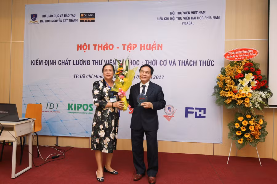 PGS.TS Nguyễn Mạnh Hùng - Hiệu trưởng Trường Đại học Nguyễn Tất Thành - tặng hoa, kỉ niệm chương cho các khách mời