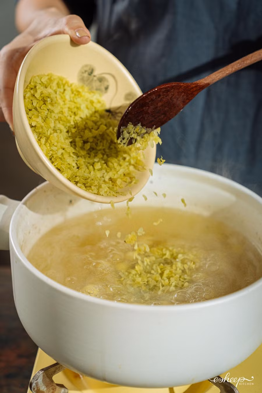 Trút cốm từ từ vào nồi và khuấy đều tay để cốm không bị vón vào nhau, nở đều như “hoa” là xong. Trút cốm từ từ vào nồi và khuấy đều tay để cốm không bị vón vào nhau, nở đều như “hoa” là xong.