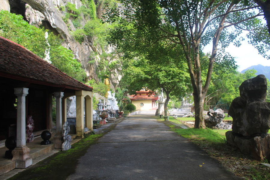 Con đường dẫn vào chùa Linh Ứng rợp bóng mát, bên cạnh là dãy núi đá hùng vĩ. Ảnh: LT.