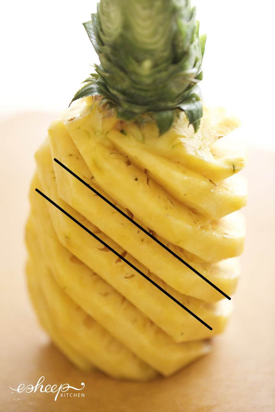 Hãy quan sát 2 đường chéo đen kia và cắt lát dứa chéo theo hình đó, thay vì cắt lát ngang quả dứa nhé!