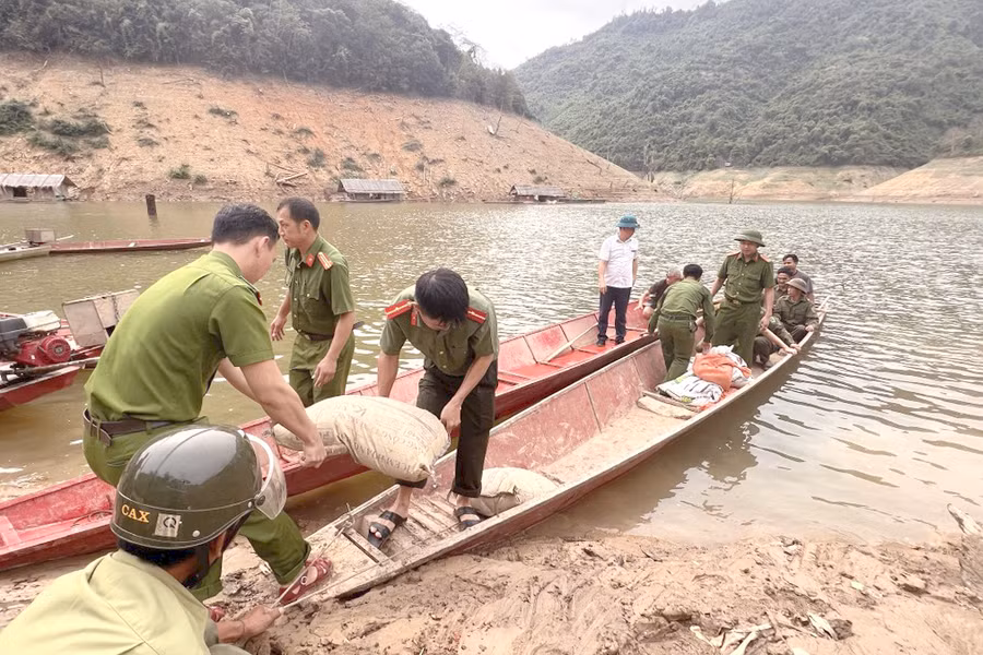 Tại một số bản làng khó khăn, lực lượng công an phải dùng thuyền nhỏ để vận chuyển vật liệu hỗ trợ người dân dựng nhà. Ảnh: CANA.