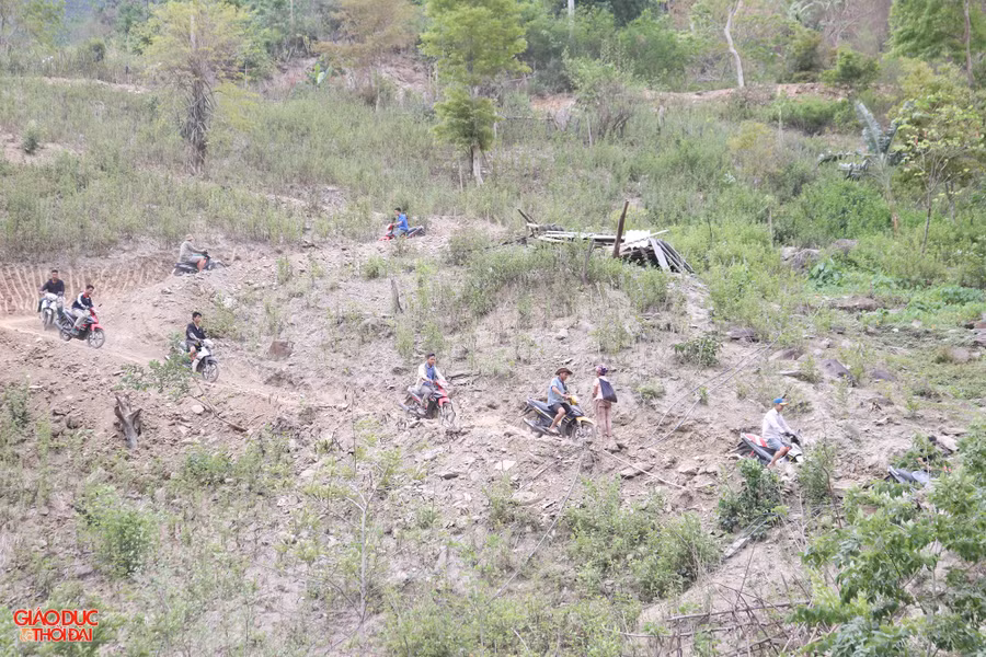 Với mục tiêu đến cuối năm 2025, cơ bản không còn hộ gia đình nghèo sinh sống trong ngôi nhà dột nát, hư hỏng, tạm bợ, có nguy cơ sập đổ, không an toàn khi sinh hoạt và sử dụng; thay vào đó có được ngôi nhà đảm bảo tiêu chuẩn 3 cứng (nền cứng, khung - tường cứng, mái cứng). Trong ảnh: Con đường đất lên bản Nhãn Cù chưa được đổ bê tông nên rất khó đi, nhiều dốc, khúc khuỷu buộc người dân phải dùng xe máy tải vật liệu lên. Ảnh: Phạm Tâm.