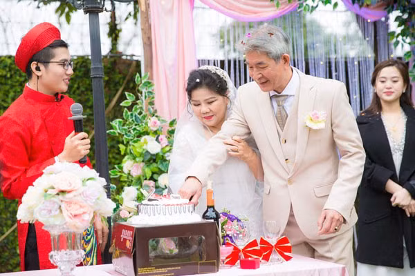 Cặp vợ chồng nghệ sĩ cắt bánh cưới.