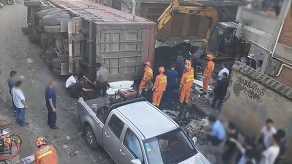 Chiếc xe container chở than lật nghiêng đã đè bẹp chiếc Peugeot nhỏ bé.