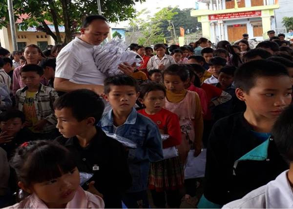 Ông Trần Xuân Khi - Giám đốc Công ty TNHH Thời trang Khánh Vy tặng áo đồng phục mới tới học sinh Nậm Chảy