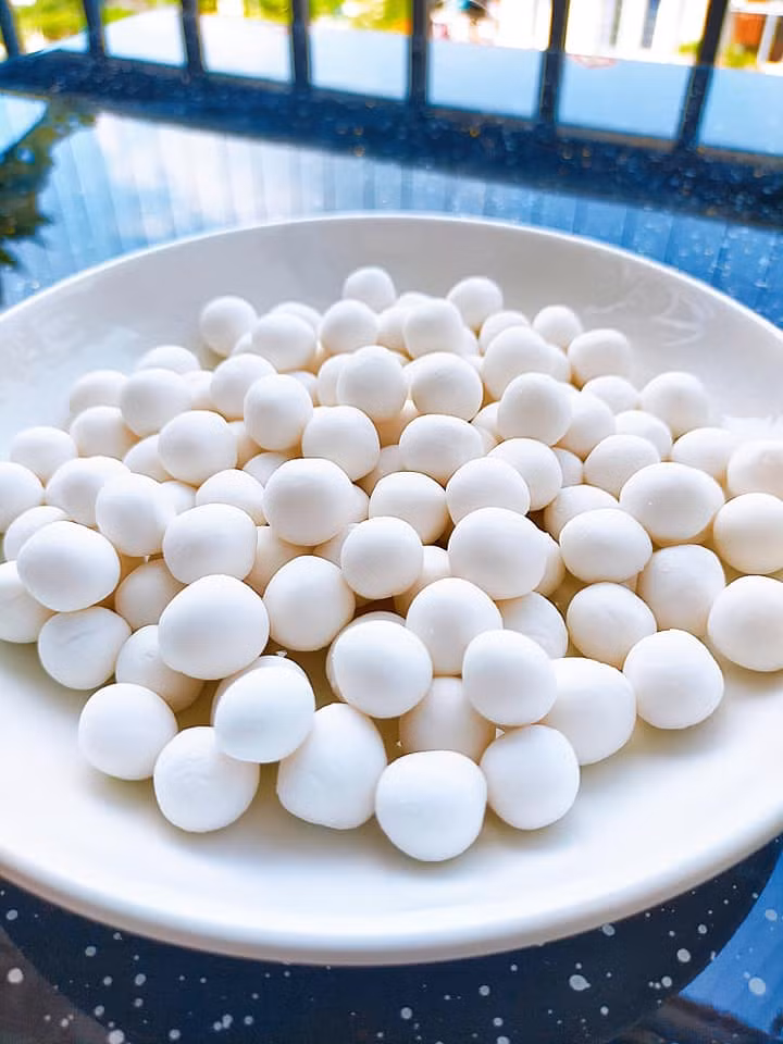 Nhào bột năng với nước nóng để nặn trân châu trắng.