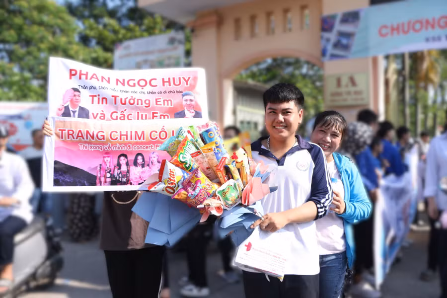 Nam sinh Phan Ngọc Huy được gia đình tặng một bó hoa "siêu to khổng lồ" bằng các loại bánh kẹo, bim bim, xúc xích để chúc mừng em đã hoàn thành kỳ thi năm nay. Ảnh: Đình Tuệ.