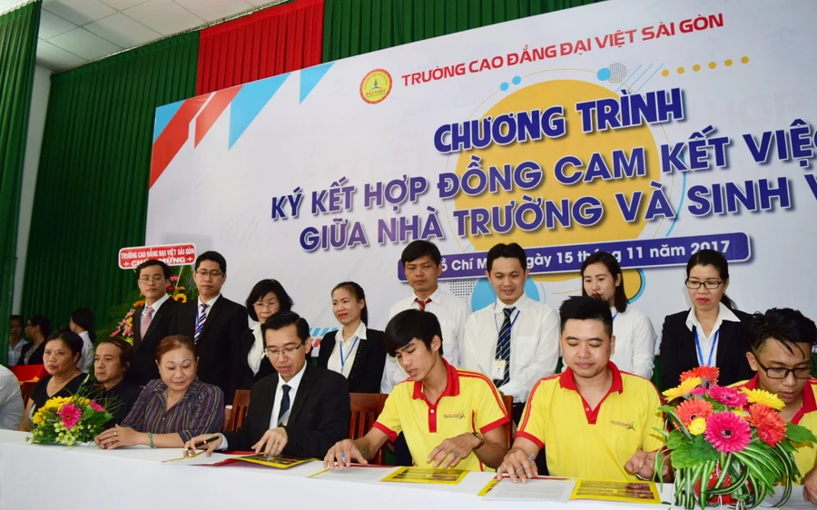 Tiến sĩ Lê Lâm-Hiệu trưởng Trường Cao đẳng Đại Việt Sài Gòn (trái) ký kết hợp đồng cam kết việc làm với từng sinh viên cuả mình