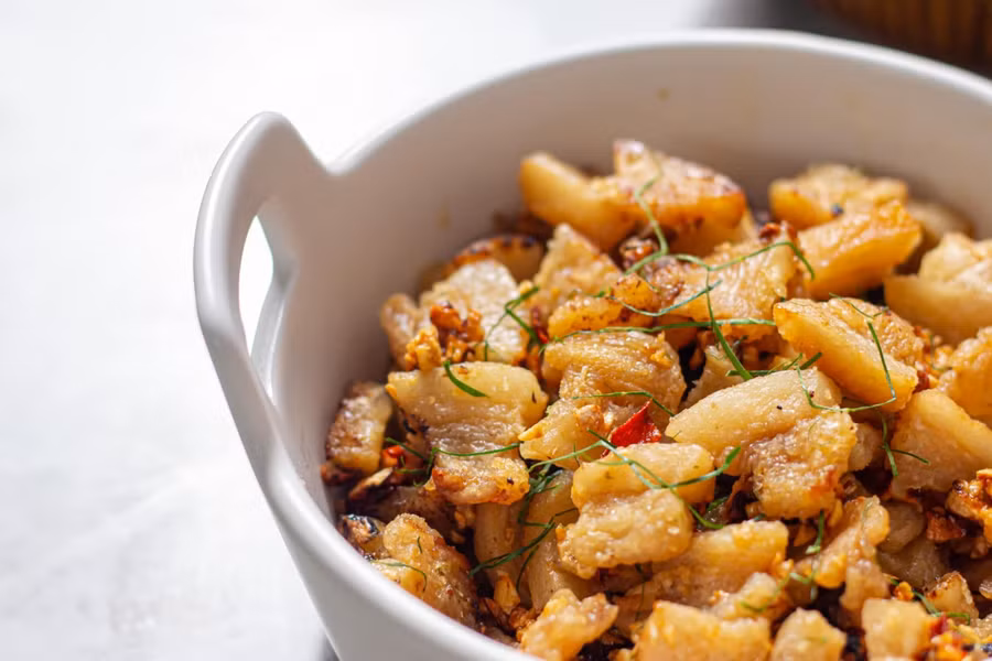 Tắt bếp trộn tóp mỡ rồi thái lá chanh rắc lên.