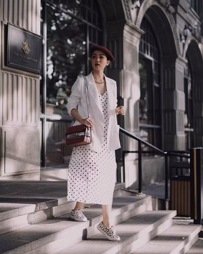 Set đồ với váy chấm bi, khoác ngoài áo blazer trắng tinh khôi rồi mix cùng giày sneakers họa tiết xuyệt tông này quả là một lựa chọn vừa trang nhã, thanh lịch nhưng cũng không kém phần thú vị, sành điệu. Set váy áo này sẽ hoàn hảo nhất nếu các nàng diện vào những ngày đông có nắng ấm áp. 