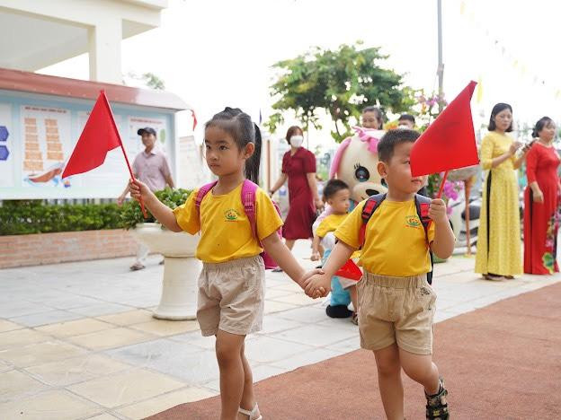 Các bé cùng dắt tay nhau đi vào lớp trong tiếng nhạc hân hoan của buổi khai trường.