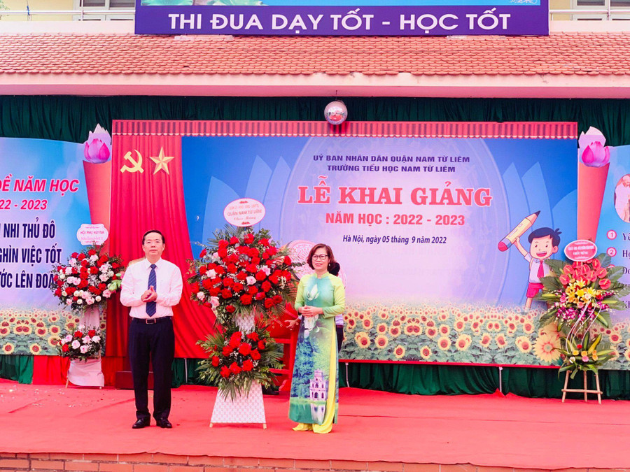 Cô Ngô Thị Thanh - Hiệu trưởng Trường Tiểu học Nam Từ Liêm đón nhận lẵng hoa chúc mừng từ ông Trần Thanh Long - Phó Chủ tịch UBND quận Nam Từ Liêm nhân dịp khai giảng năm học mới.