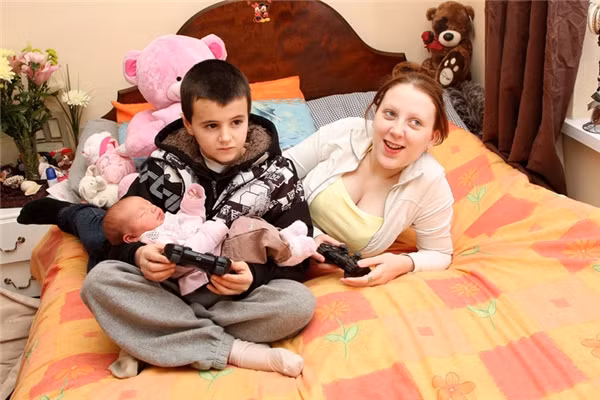 Vừa bế con vừa chơi điện tử.