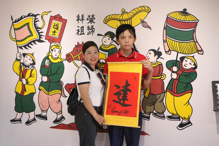 Mẹ con chị Nguyễn Thị Chúc và em Quang Việt cùng xin chữ của ông Đồ để lấy may mắn trong kỳ thi quan trọng sắp tới.